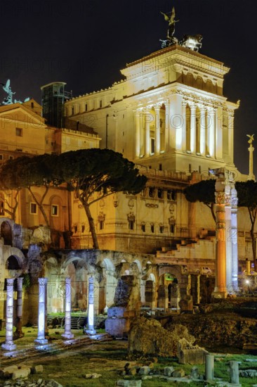 View at night over the Caesar Forum of Julius Caesar, illuminated in colour from the front, with columns of the Temple of Venus Genetrix towering behind it on the right at the edge of the picture