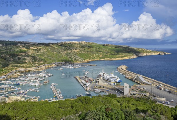 View of Gozo Mgarr Harbour harbour basin with small boats yachts yachts on the left, in the centre of the picture jetty for ferries from Valletta island Malta and moored ferry car ferry, Mgarr, Gozo, Malta