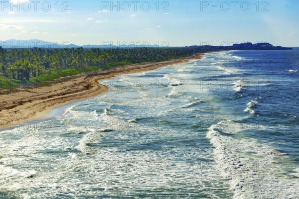 Aerial view of strong surf rolling in with whitecaps at coastal cut-off near Punta Cana, Dominican Republic, Caribbean