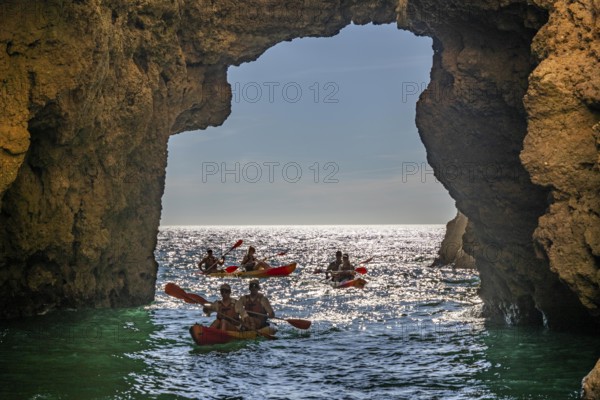 Tour with sea kayaks to the Ponta da Piedade rocky coast, rugged coastal landscape, right next to the city centre of Lagos, in the west of the Algarve, Portugal