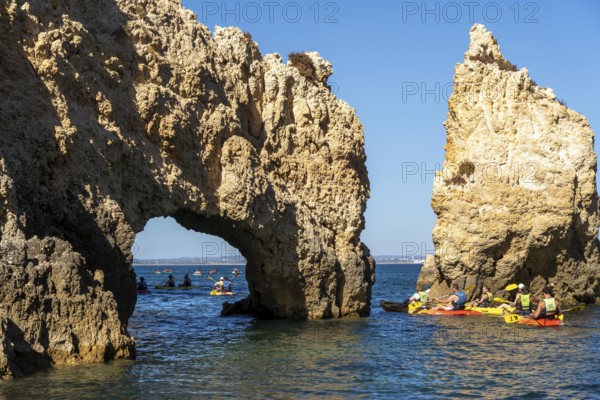 Tour with sea kayaks to the Ponta da Piedade rocky coast, rugged coastal landscape, right next to the city centre of Lagos, in the west of the Algarve, Portugal