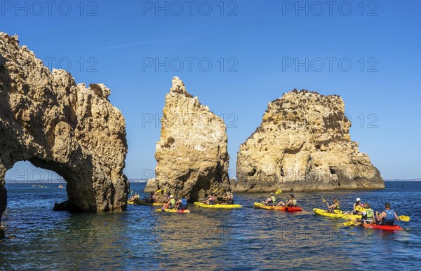 Tour with sea kayaks to the Ponta da Piedade rocky coast, rugged coastal landscape, right next to the city centre of Lagos, in the west of the Algarve, Portugal