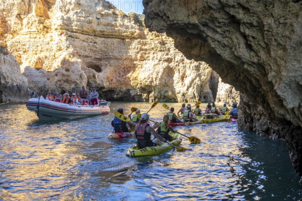 Tour with sea kayaks to the Ponta da Piedade rocky coast, rugged coastal landscape, right next to the city centre of Lagos, in the west of the Algarve, Portugal