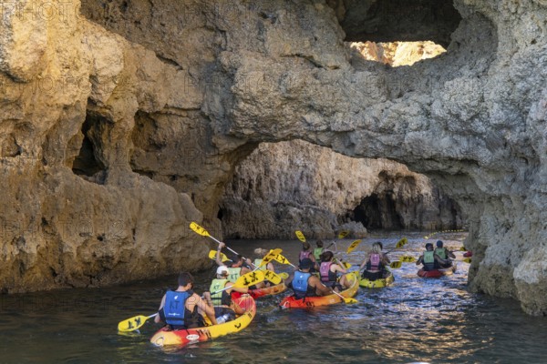 Tour with sea kayaks to the Ponta da Piedade rocky coast, rugged coastal landscape, right next to the city centre of Lagos, in the west of the Algarve, Portugal