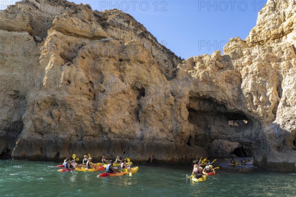 Tour with sea kayaks to the Ponta da Piedade rocky coast, rugged coastal landscape, right next to the city centre of Lagos, in the west of the Algarve, Portugal