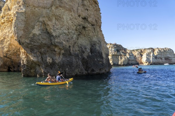 Tour with sea kayaks to the Ponta da Piedade rocky coast, rugged coastal landscape, right next to the city centre of Lagos, in the west of the Algarve, Portugal