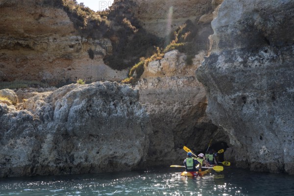 Tour with sea kayaks to the Ponta da Piedade rocky coast, rugged coastal landscape, right next to the city centre of Lagos, in the west of the Algarve, Portugal