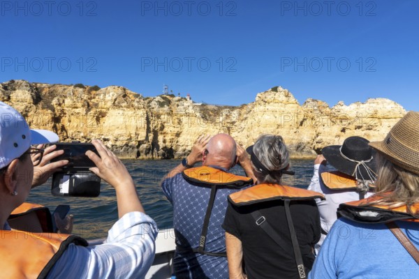 Tour with a small motorboat to the Ponta da Piedade rocky coast, rugged coastal landscape, right next to the city centre of Lagos, in the west of the Algarve, Portugal