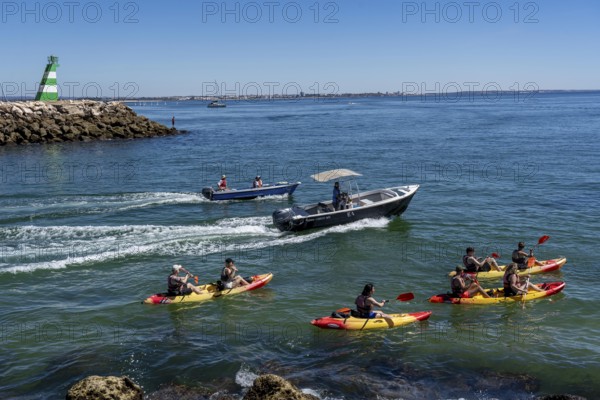 Kayak tours to the rocky coast of Ponta da Piedade, groups of tourists kayak on the sea to the rugged coastline of Lagos, in the west of the Algarve, Portugal
