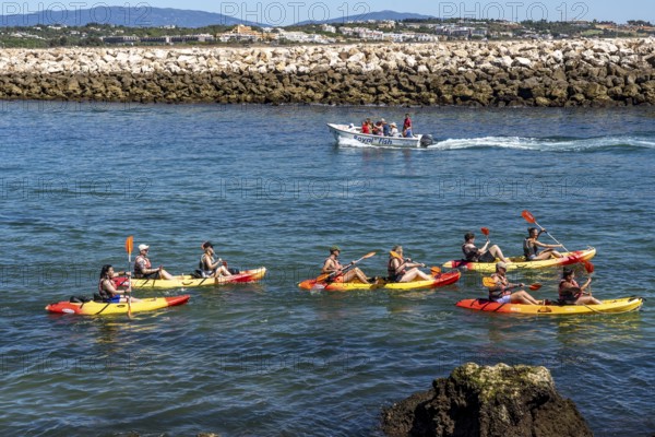 Kayak tours to the rocky coast of Ponta da Piedade, groups of tourists kayak on the sea to the rugged coastline of Lagos, in the west of the Algarve, Portugal
