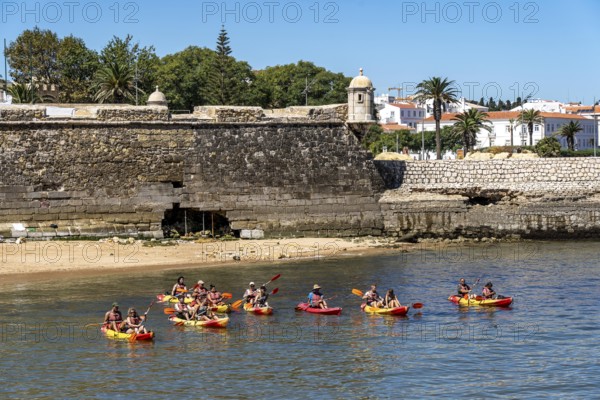 Kayak tours to the rocky coast of Ponta da Piedade, groups of tourists in kayaks on the sea to the rugged coastal landscape, from Lagos, in the west of the Algarve, Portugal Forte Ponta da Bandeira