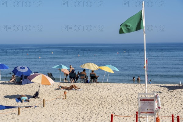 Kilometre-long sandy beach Praia do Barril, on the island off Santa Luzia, green flag indicates swimming permitted, lifeguards on the beach, Algarve, Portugal