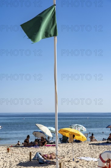 Kilometre-long sandy beach Praia do Barril, on the island off Santa Luzia, green flag indicates swimming permitted, lifeguards on the beach, Algarve, Portugal