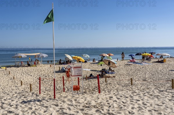 Kilometre-long sandy beach Praia do Barril, on the island off Santa Luzia, green flag indicates swimming permitted, lifeguards on the beach, Algarve, Portugal