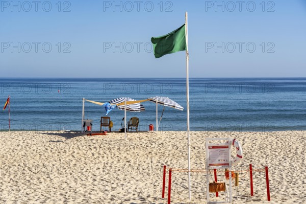 Kilometre-long sandy beach Praia do Barril, on the island off Santa Luzia, green flag indicates swimming permitted, lifeguards on the beach, Algarve, Portugal