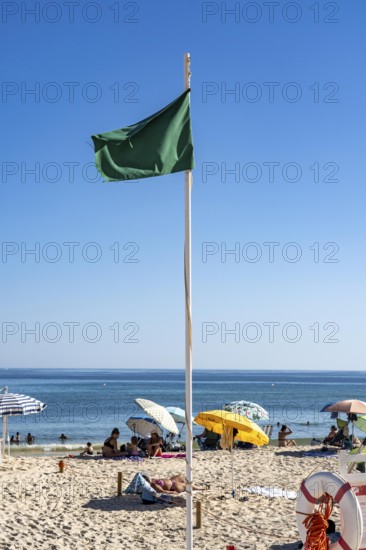 Kilometre-long sandy beach Praia do Barril, on the island off Santa Luzia, green flag indicates swimming permitted, lifeguards on the beach, Algarve, Portugal