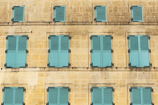 Closed, green shutters, historic house façade, yellow sandstone, Marville, Renaissance village, Département Meuse, Grand Est, France