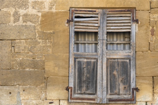 Closed wooden window, historic house facade, yellow sandstone, Marville, Renaissance village, Département Meuse, Grand Est, France