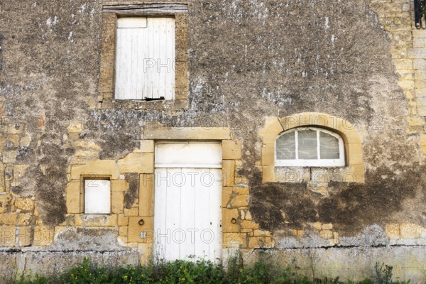 Closed white wooden door and windows, historic house façade, yellow sandstone, Marville, Renaissance village, Département Meuse, Grand Est, France