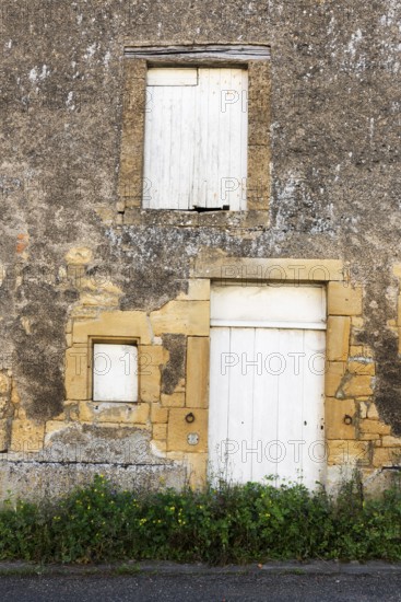Closed white wooden door and windows, historic house façade, yellow sandstone, Marville, Renaissance village, Département Meuse, Grand Est, France