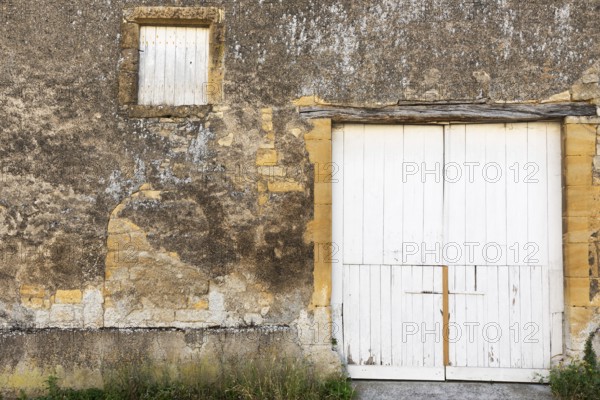 Closed white wooden door and windows, historic house façade, yellow sandstone, Marville, Renaissance village, Département Meuse, Grand Est, France