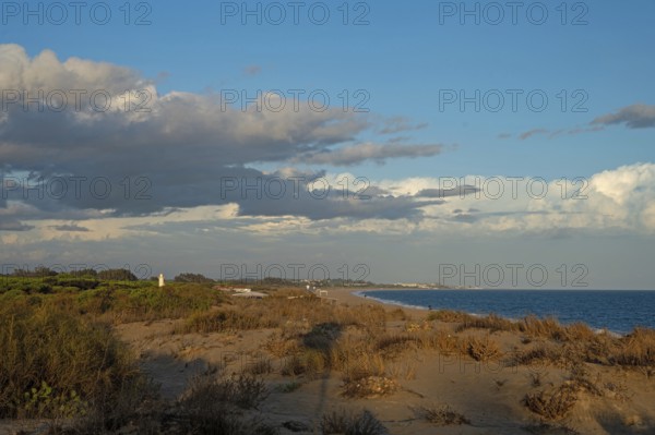 View over the dunes in Isla Cristina in the golden hour, Atlantic Ocean, Atlantic Ocean, sandy beach and lighthouse, Isla Cristina, Andalusia, Spain