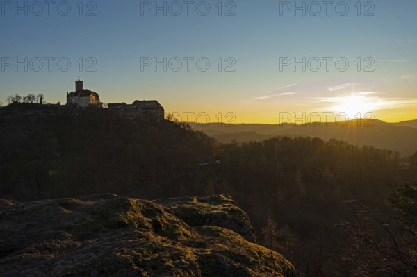 View of Wartburg Castle with the setting sun and the Thuringian Forest, Eisenach, Thuringia, Germany