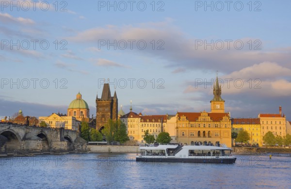 View of old town with Charles Bridge (Karluv Most) on Vltava river and Old Town Bridge Tower, famous tourist destination in Prague, Czech Republic (Czechia), at sunset