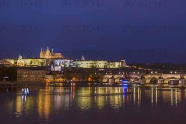 Vltava river with famous Hradcany castle and St. Vitus Cathedral in Prague, Czech Republic, by night