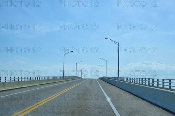 An empty, straight bridge stretches under a blue sky and offers a peaceful, clear view, A. Max Brewer Bridge, Titusville, Florida, USA