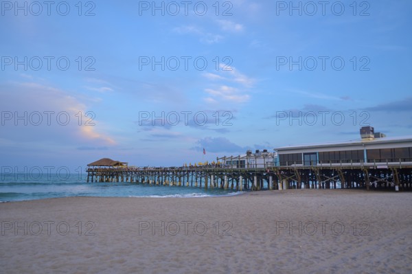 A quiet beach with a long wooden pier under a blue evening sky, Westgate Cocoa Beach Pier, Cocoa Beach, Port Canaveral, Florida, USA