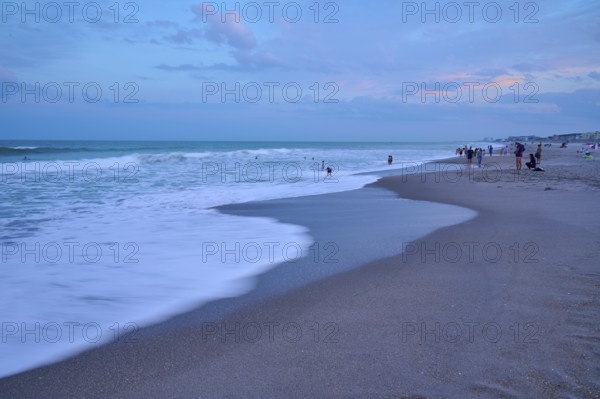 Wave scene on the beach in the evening with people in the background, Cocoa Beach, Port Canaveral, Florida, USA