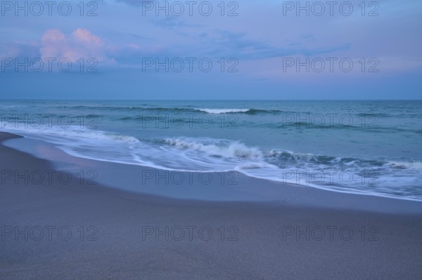 Beach scene with calming waves and blue evening sky, Cocoa Beach, Port Canaveral, Florida, USA