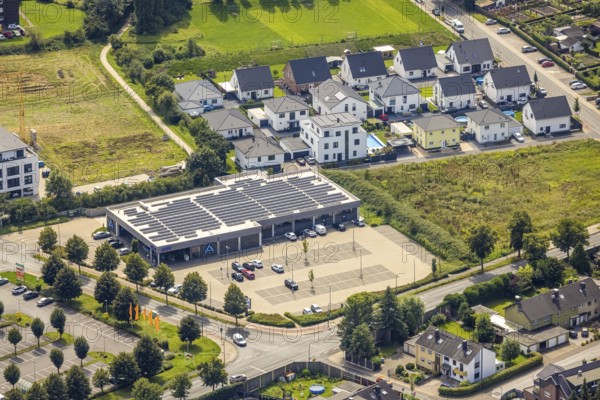 Aerial view, Aldi supermarket with solar roof and new housing estate Büscherstrasse in Bergkamen, Ruhr area, North Rhine-Westphalia, Germany, Bergkamen, DE, shopping markets, shopping square, shopping centre, Europe, property tax, real estate, aerial view, aerial photography, aerial photography, local supply centre, overview, bird's-eye view, residential area, residential buildings, residential quality, residential quarter, housing estate, birds-eyes view, overview