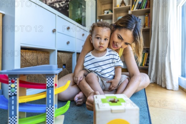 Happy mother and son playing with educational toys, enjoying quality time together in a cozy home environment