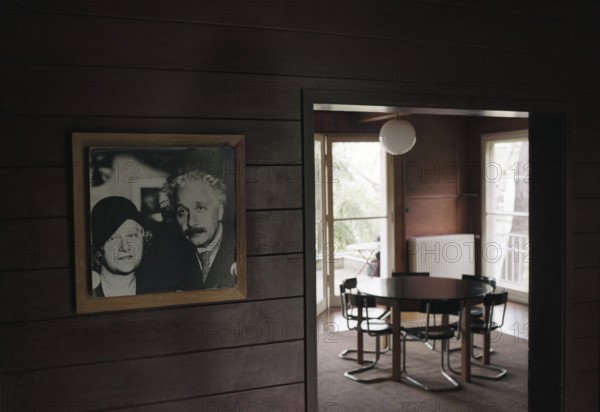 Potsdam-Caputh, DEU, Germany. 26.04.2002 - Albert Einstein's summer residence: living room of the famous scientist. Photo of the Einstein couple. (table, interior, furniture, interior, history, museum) -
