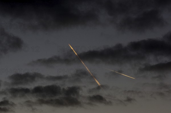 Contrails from passenger aircraft in the evening sky over Berlin