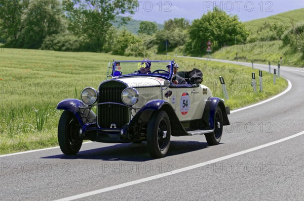 A white and blue classic car with driver on a sunny country road, classic car, car race, Mille Miglia, 1000 Miglia, 2015, Tuscany, Rome Lake Garda, Italy