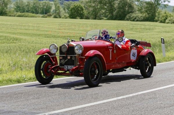 Red classic car with two men on a sunny road next to fields, classic car, car race, Mille Miglia, 1000 Miglia, 2015, Tuscany, Rome Lake Garda, Italy