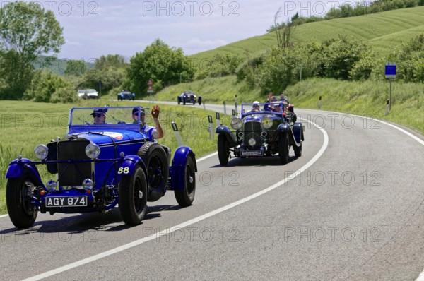 Two blue classic cars driving one behind the other on a winding country road, classic car, car race, Mille Miglia, 1000 Miglia, 2015, Tuscany, Rome Lake Garda, Italy