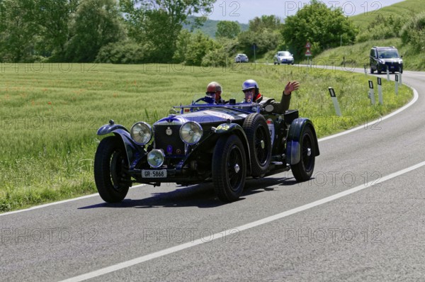 Black classic car with waving driver on winding road in idyllic landscape, classic car, car race, Mille Miglia, 1000 Miglia, 2015, Tuscany, Rome Lake Garda, Italy