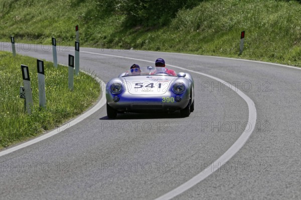 A silver racing car with two people drives swiftly along a winding road, classic car, car race, Mille Miglia, 1000 Miglia, 2015, Tuscany, Rome Lake Garda, Italy