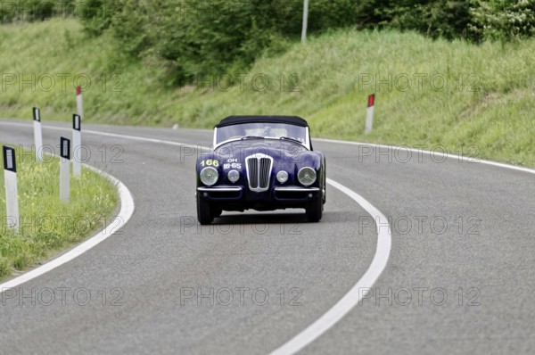 A dark classic car drives alone on a winding country road, classic car, car race, Mille Miglia, 1000 Miglia, 2015, Tuscany, Rome Lake Garda, Italy