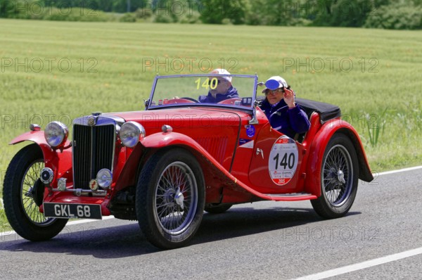 A red classic roadster drives along a rural road in fine weather, classic car, car race, Mille Miglia, 1000 Miglia, 2015, Tuscany, Rome Lake Garda, Italy
