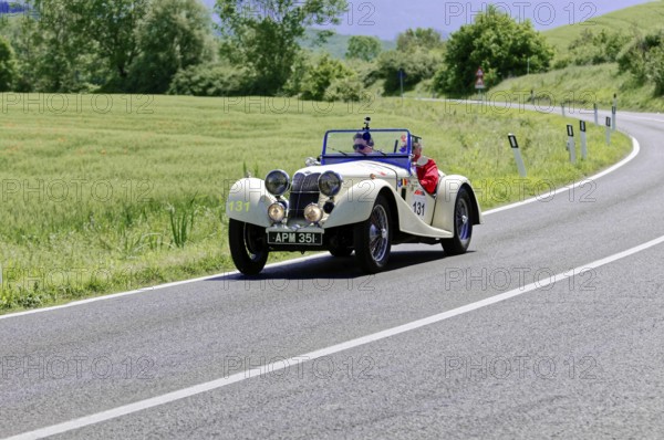 Cream-coloured classic car on a rural road with a green natural backdrop, classic car, car race, Mille Miglia, 1000 Miglia, 2015, Tuscany, Rome Lake Garda, Italy