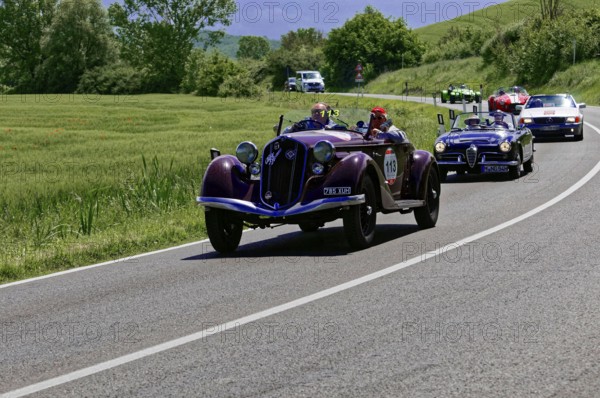 A red classic car leads a group of classic cars on a country road, classic car, car race, Mille Miglia, 1000 Miglia, 2015, Tuscany, Rome Lake Garda, Italy