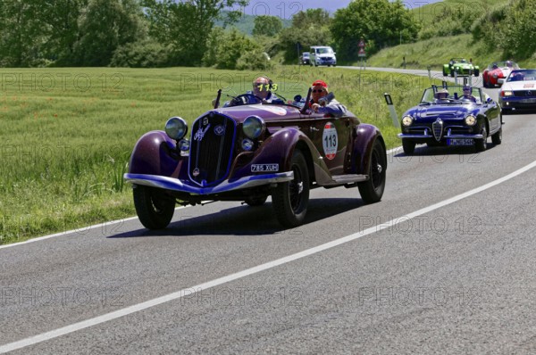 Two classic cars driving with several vehicles on a country road, classic car, car race, Mille Miglia, 1000 Miglia, 2015, Tuscany, Rome Lake Garda, Italy