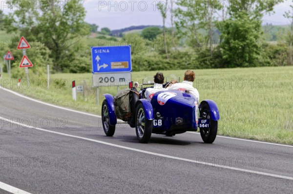 Blue classic car in the direction of Siena on a country road through the Italian countryside, classic car, car race, Mille Miglia, 1000 Miglia, 2015, Tuscany, Rome Lake Garda, Italy