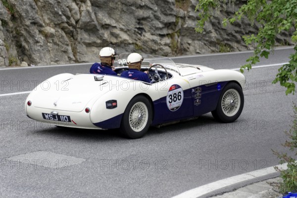 No. 386, Austin Healey 100 S, built in 1955, white classic car convertible travelling on a winding road, Mille Miglia 2014 or 1000 Miglia, classic car race, San Marino, Italy