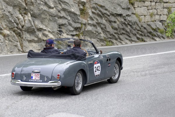 Grey vintage convertible driving on a road along rocky landscape, Mille Miglia 2014 or 1000 Miglia, vintage car race, San Marino, Italy